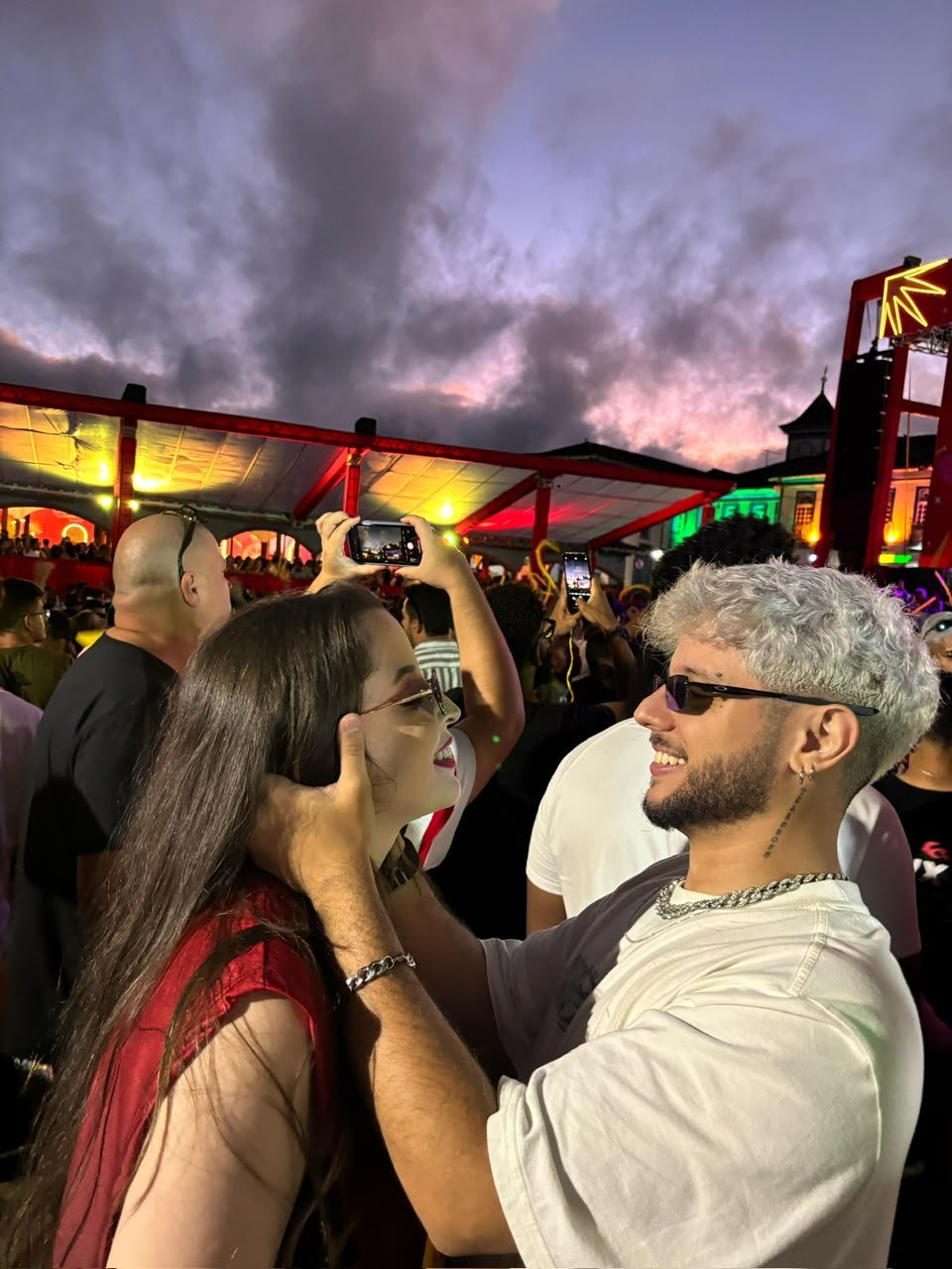 Marta e Matheus se olhando sorrindo no Mercado Velho ao amanhecer, no Carnaval de Diamantina